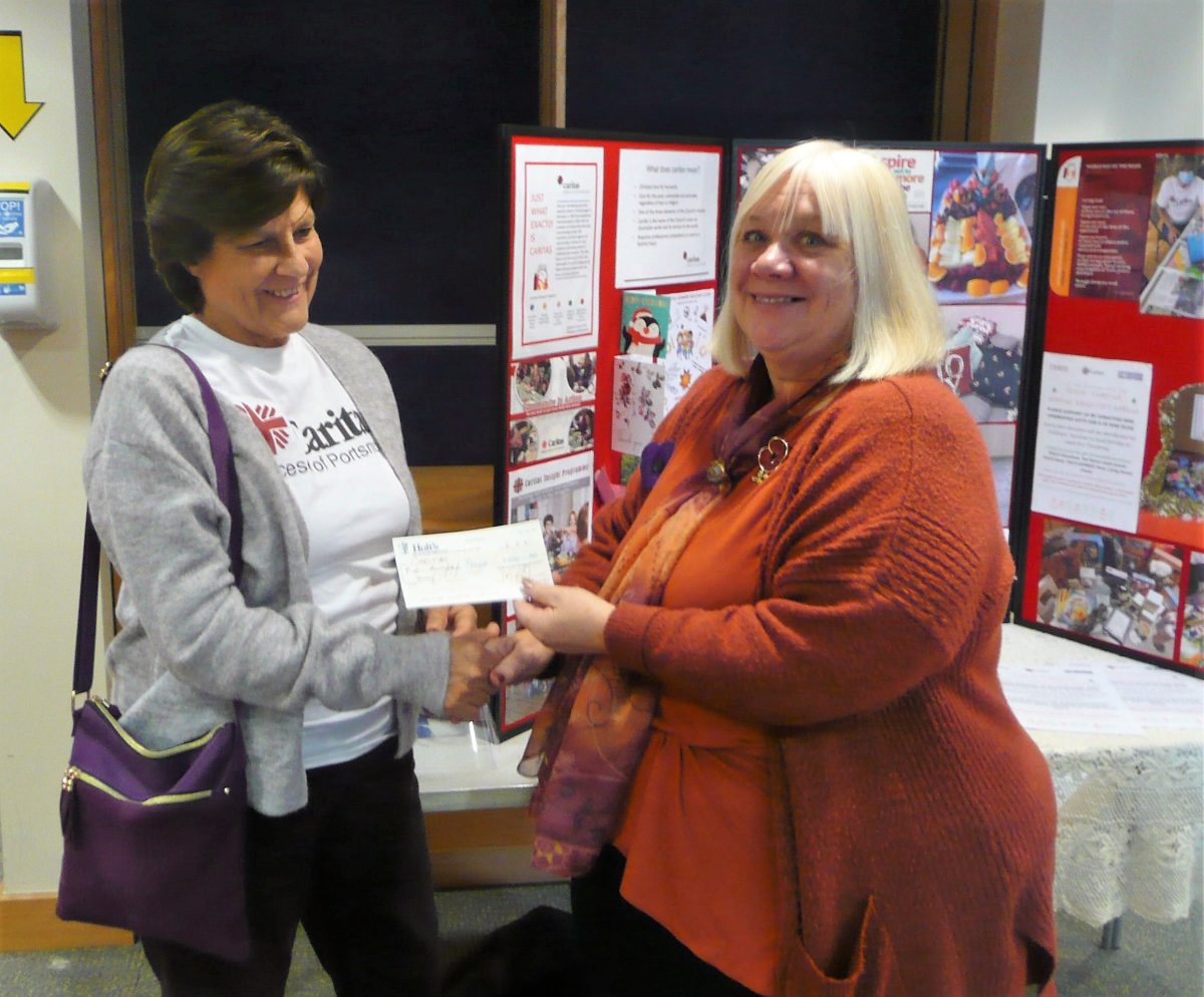 Jill Blackburn receives a cheque from Carol Rayner on behalf of Caritas